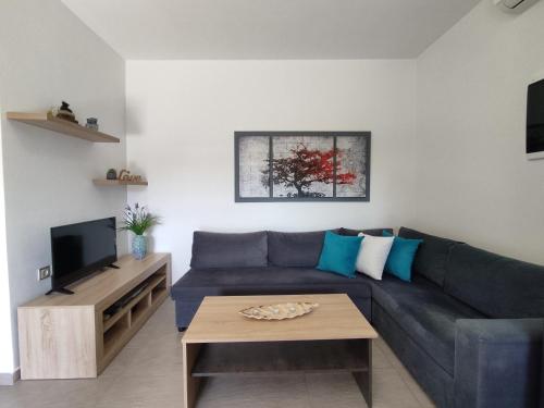 uma sala de estar com um sofá azul e uma mesa de centro em Psaromoura Apartment 2 em Agia Pelagia