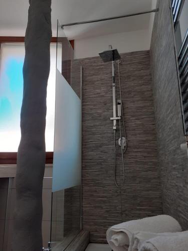 a bathroom with a shower with a stone wall at Sweet Suite Margherita in Margherita di Savoia