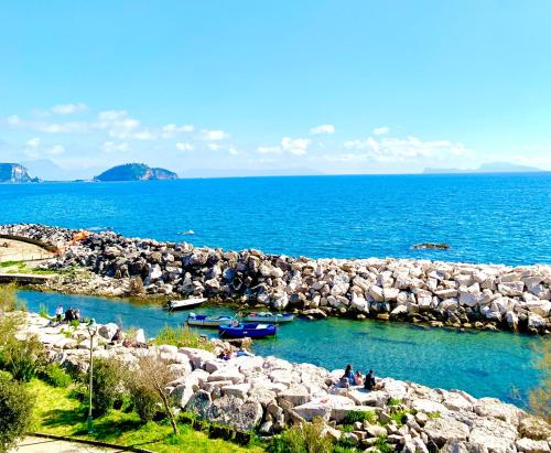 a group of people sitting on the rocks in the water at Artis Mare in Pozzuoli