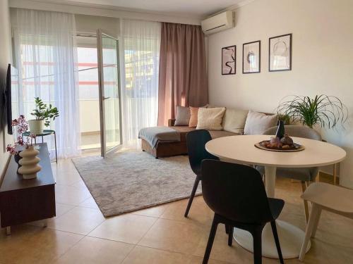 a living room with a couch and a table with chairs at East Coast Senses in Thessaloniki