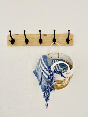 a wooden towel rack with a basket on a wall at Caparica Rooftop Beach Apartment in Costa da Caparica
