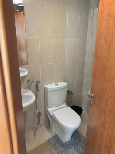a bathroom with a toilet and a sink at One Bedroom Apartment- IMPZ in Dubai