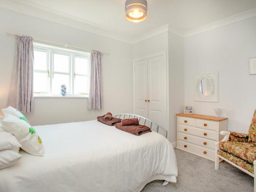 a white bedroom with a bed and a chair at Valley View - Uk43268 in Luppitt