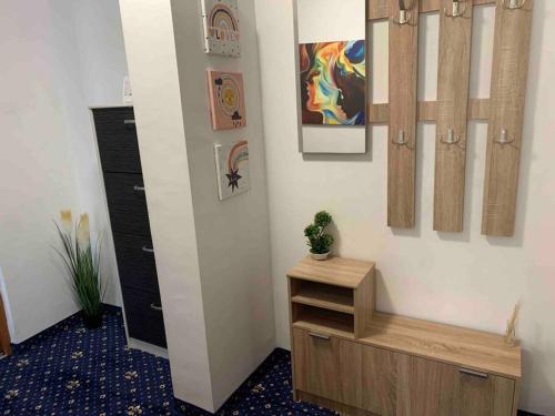Zimmer mit einem Flur mit einer Holzbank und Gemälden in der Unterkunft Cozy & warm studio in Bukarest