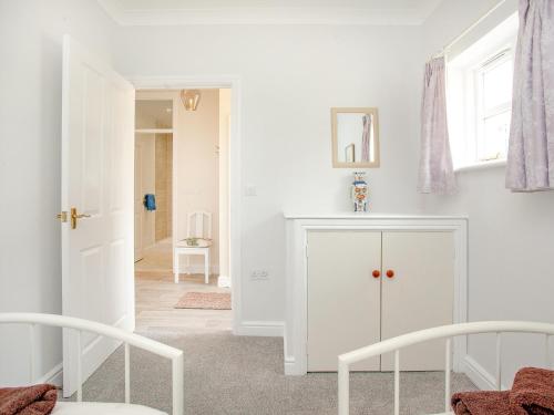 a white room with two chairs and a white cabinet at Valley View - Uk43268 in Luppitt