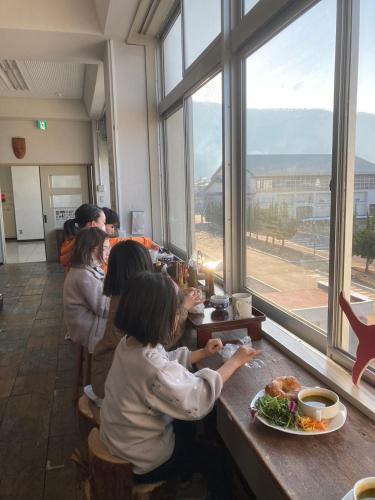 a group of people sitting at a table in a restaurant at Yamagata Guesthouse山形ゲストハウス in Murayama