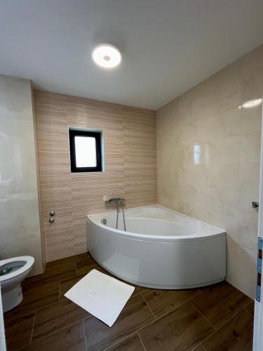 a large white tub in a bathroom with a sink at Apartment Lux Lucis in Livno