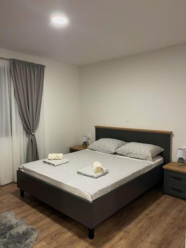 a bedroom with a large bed with two hats on it at Apartment Lux Lucis in Livno