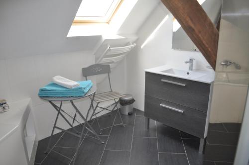 a small bathroom with a sink and a stool at Demeure de BoisClaireau in Le Mans