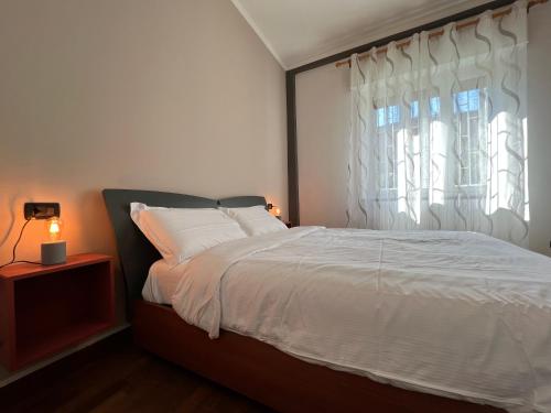 um quarto com uma cama branca e uma janela em Relax Segrate em Segrate