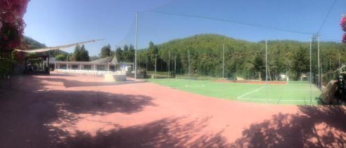 un court de tennis en face d'un bâtiment dans l'établissement Gargano Vacanza, à Peschici