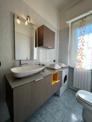 uma casa de banho com um lavatório e uma máquina de lavar roupa em Relax Segrate em Segrate