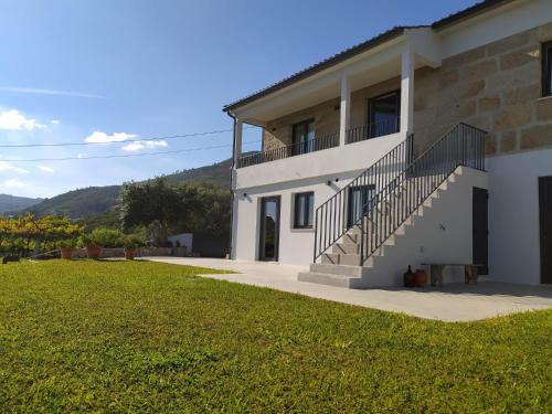 a white house with stairs and a grass yard at Casa do Crasto in Soajo