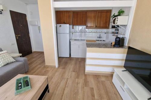 a small kitchen and living room with a couch at Incredible seafront with sunrise and sunset views in Benicàssim