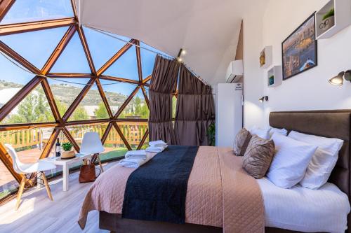 sypialnia z łóżkiem i dużym oknem w obiekcie Amazing Cyprus Glamping Domes - Glamping Cyprus w Pafos