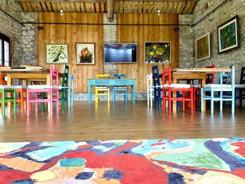 Habitación con mesas, sillas y TV de pantalla plana. en Casa delle Arti Fattoria dei fiori, en Sospirolo