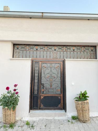 於爾居普的住宿－Unique villa in Cappadocia，两棵盆栽植物的楼房的门