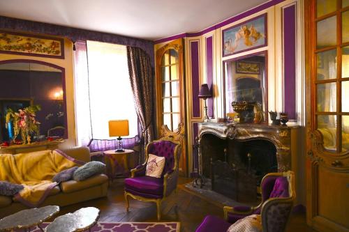 d'un salon avec des murs violets et une cheminée. dans l'établissement Location meublé de tourisme La Rose des Fables, à Château-Thierry