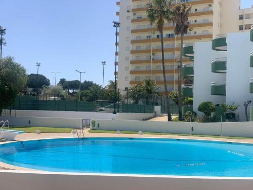 Una gran piscina azul frente a un edificio en Sunsetview, en Portimão
