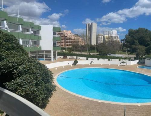 Una gran piscina azul frente a un edificio en Sunsetview, en Portimão