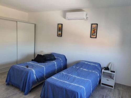 1 Schlafzimmer mit 2 Betten und blauer Bettwäsche in der Unterkunft Departamento en Arroyito- Córdoba in Arroyito