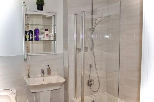 a white bathroom with a shower and a sink at Apartment in the heart of london Greenford in Perivale