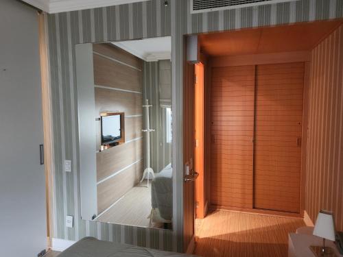 a bedroom with a sliding glass door with a television at La Bella Cintra, 672 in São Paulo
