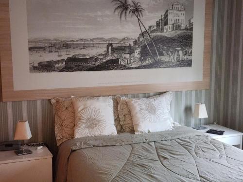 a bedroom with a bed with a picture above it at La Bella Cintra, 672 in São Paulo