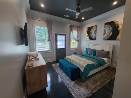 a bedroom with a bed with a blue comforter at West End Modern Atlanta 3 Bedroom Bungalow in Atlanta