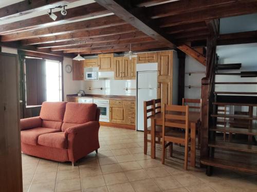 a kitchen with a couch and a chair and a table at Apartamentos LLave de Santillana in Santillana del Mar