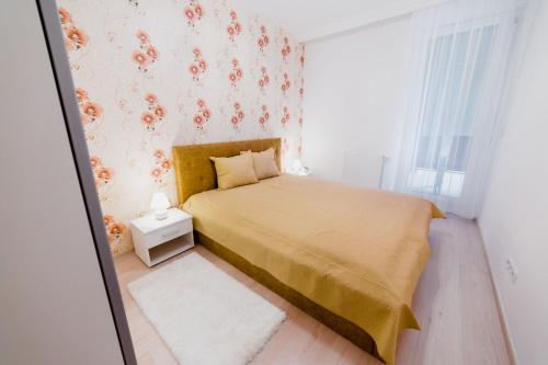 a small bedroom with a bed with a yellow bedspread at Corvin Promenade in Budapest