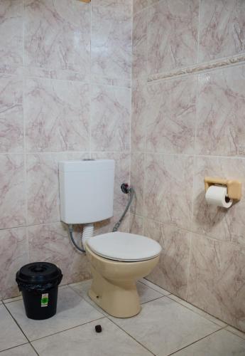 a bathroom with a toilet and a trash can at SIGRUM Hostel in San Rafael