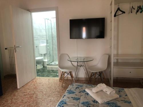 a room with a table and chairs and a television at Bed a Cavour in Gaeta