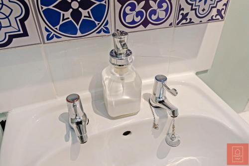 zlew w łazience z butelką mydła w obiekcie Cheerful Stays: Spacious Flat in Vibrant Leith w Edynburgu