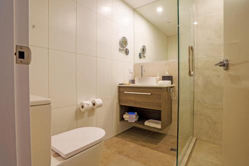 La salle de bains est pourvue de toilettes et d'une douche en verre. dans l'établissement The Sebel Wellington Thorndon, à Wellington