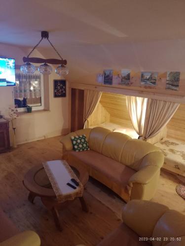 a living room with a couch and a table at Agrohaczow za rzeką Apartament 8-osobowy in Haczów