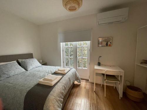 a bedroom with a bed and a desk and a window at RETIRO 401 one-bedroom apartment in Guimarães