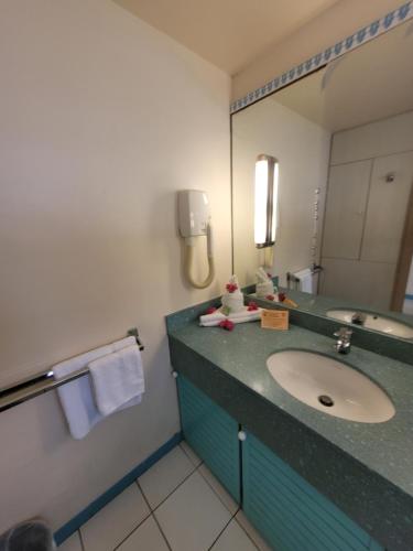 a bathroom with a sink and a mirror at Hotel Carayou piscine et Spa in Les Trois-Îlets