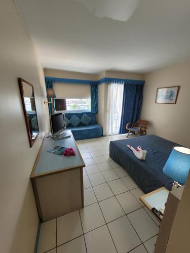 a hotel room with a bed and a kitchen at Hotel Carayou piscine et Spa in Les Trois-Îlets