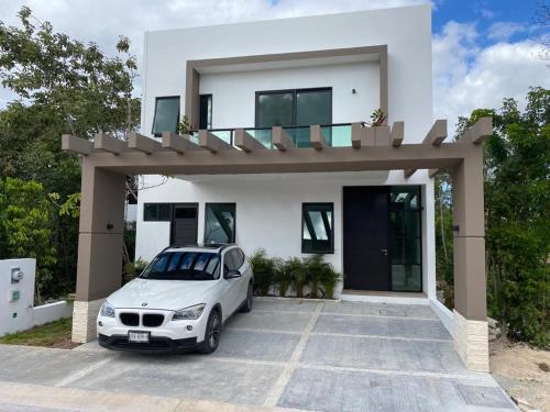 a white car parked in front of a white house at CASA DE MARIA in Cancún
