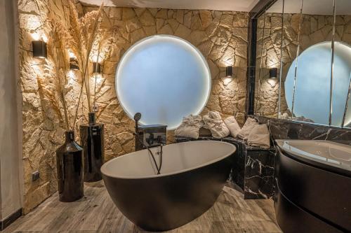 a bathroom with a large tub and a large mirror at Palais Mirage d'Atlas - Restaurant & Spa & Day Pass in Marrakesh