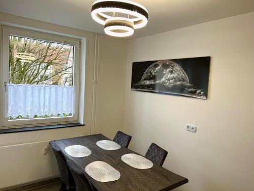 ein Esszimmer mit einem Tisch und einem Fenster in der Unterkunft Modern & Schick in Hannover