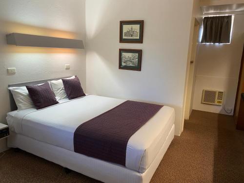 1 dormitorio con 1 cama grande en una habitación en Ben Hall Motor Inn, en Forbes