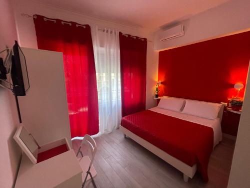 a red bedroom with a bed and red curtains at La Stazione 92 in Catania