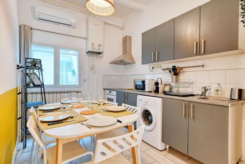 - une cuisine avec une table, des chaises et un évier dans l'établissement THIBAUD - T4 terrasse à 15 min à pied du Métro, à Marseille