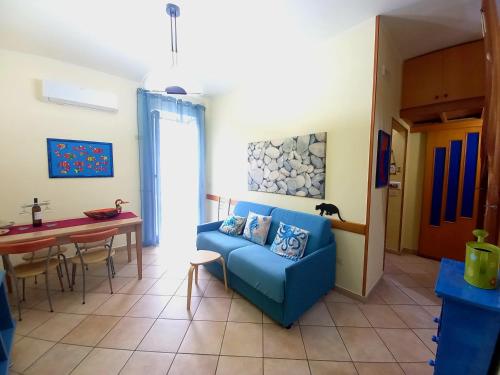 a living room with a blue couch and a table at Pozzuoli 100per100 Home in Pozzuoli