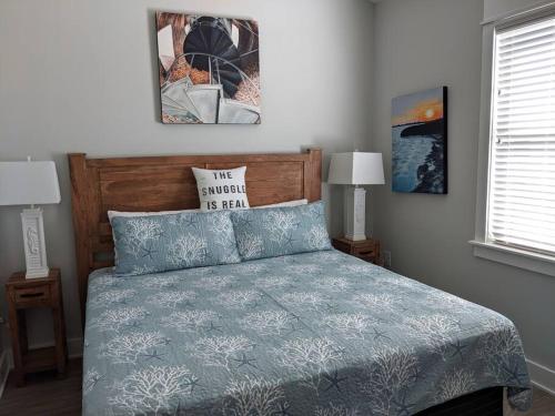 a bedroom with a bed with a blue comforter at Salty Kisses - Let The Beach Reconnect Your Souls in Corolla