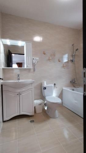 uma casa de banho com um WC, um lavatório e uma banheira em La Amy em Pangarati