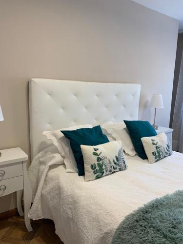 a bedroom with a bed with blue and white pillows at Fogar de Aurora in Portomarin
