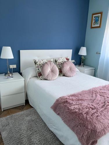 a bedroom with a bed with two tables and two lamps at Fogar de Aurora in Portomarin